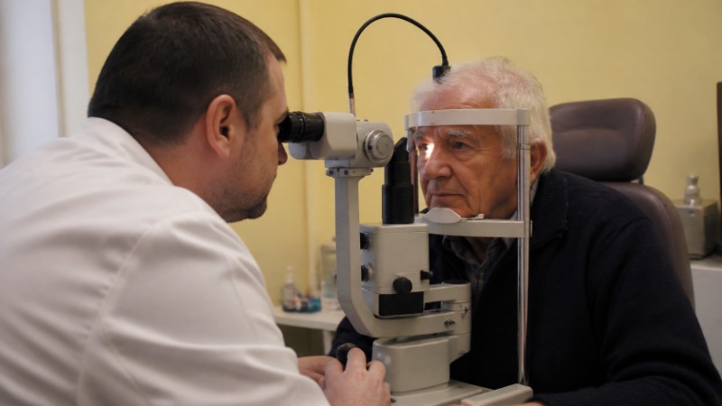 Starší muž v ordinaci praktického lékaře při vyšetření zraku před vydáním posudku o zdravotní způsobilosti k řízení